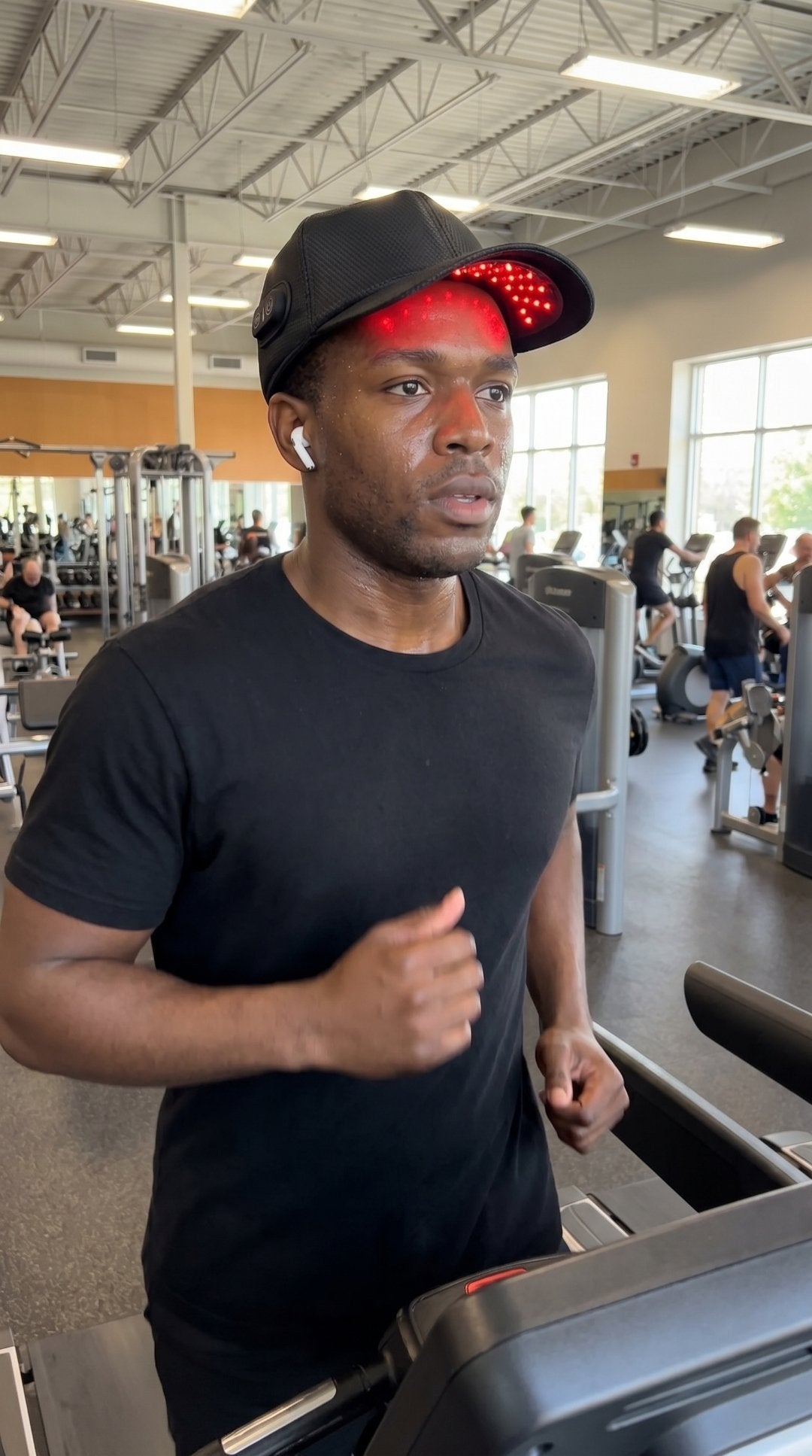 Man wearing the Revanus cap at the gym on a treadmill